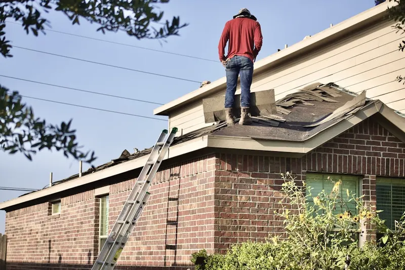 Professional roofer working on a residential roof in Welcome